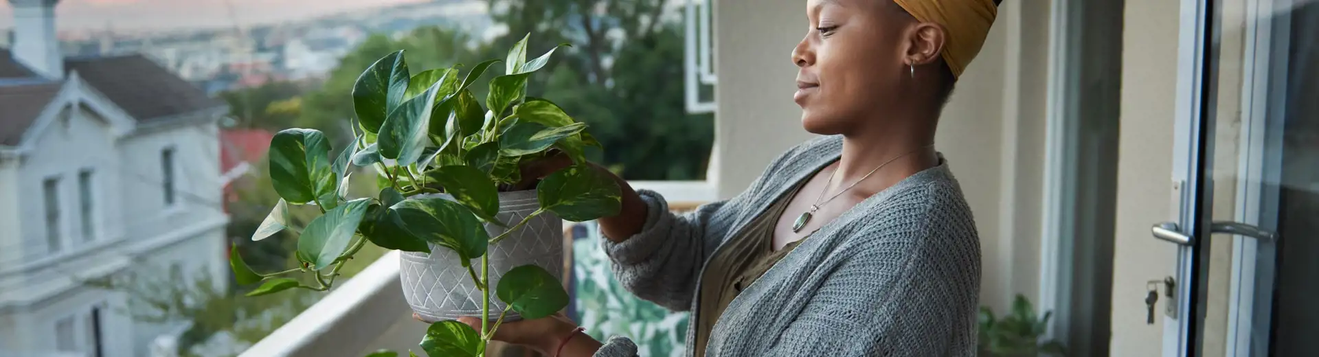 Femme rempotant une plante sur son balcon
