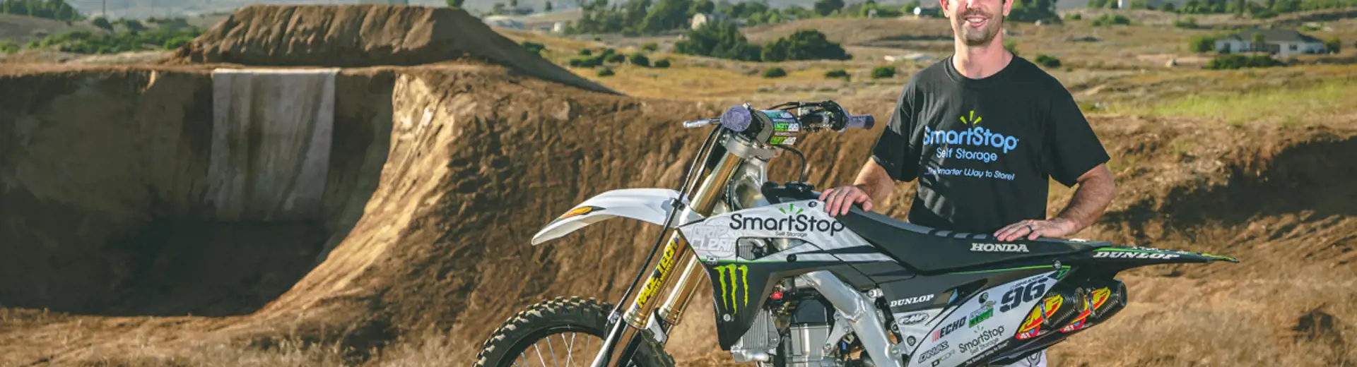 Bryce Hudson, Soap Boy, standing behind smartstop sponsored motorcycle for upcoming x-games