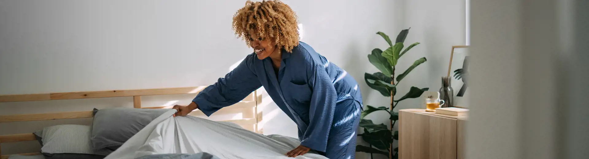 woman removing comforter from bed