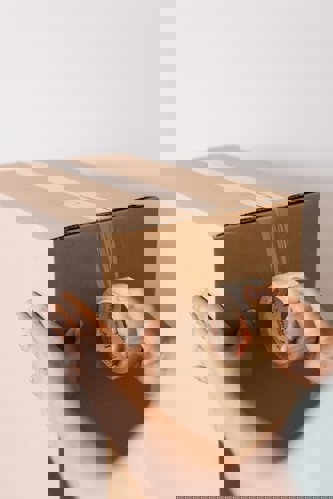 person taping up storage box