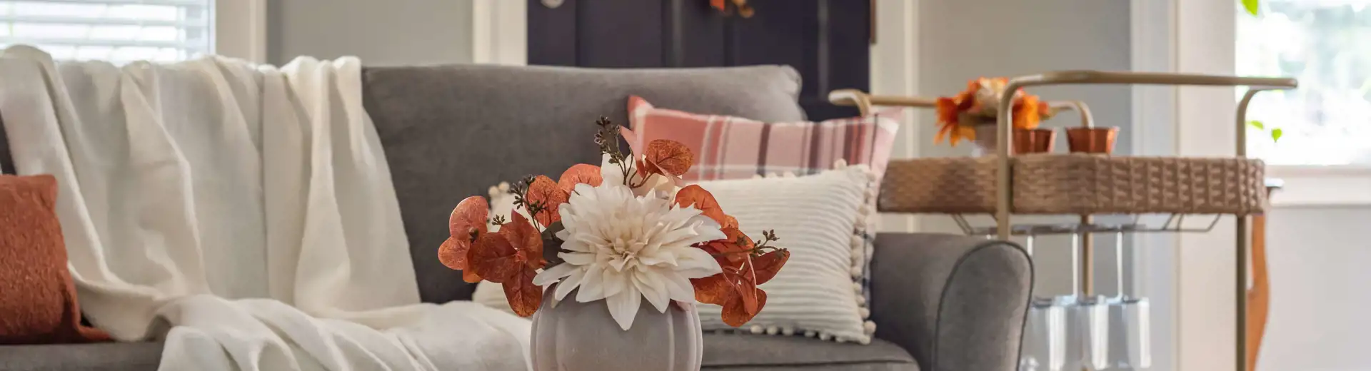 cozy fall living room with throw blanket patterned pillow wreath on door