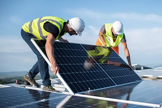Image of workers installing solar panels on roof of a SmartStop location